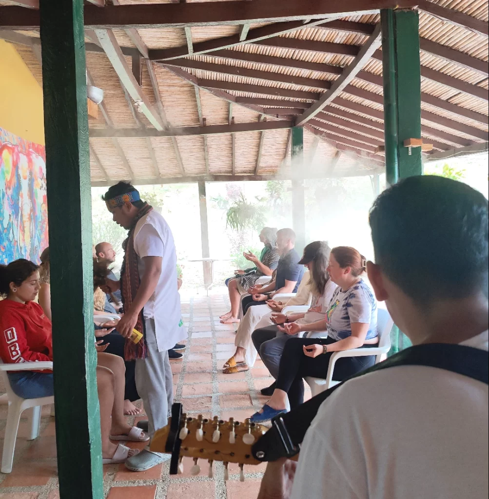 man performing ayahuasca while group people meditate